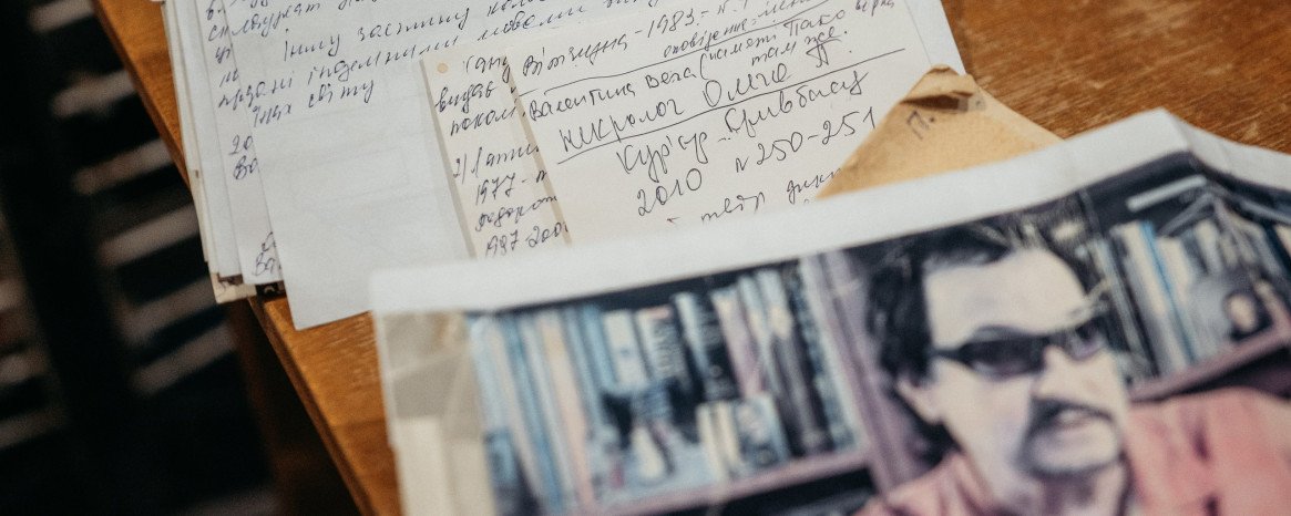 Рукописний текст та фото на письмовому столі.