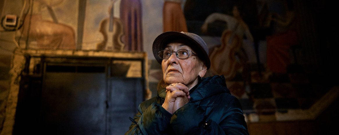 Жінка стоїть у холі колишнього парадного входу до луцького музучилища, згодом Луцької тюрми