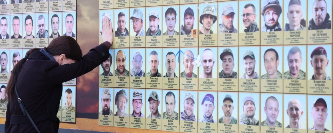 жінка біля фотостенду