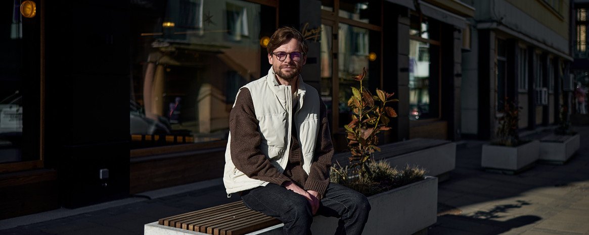 Чоловік сидить на лавці