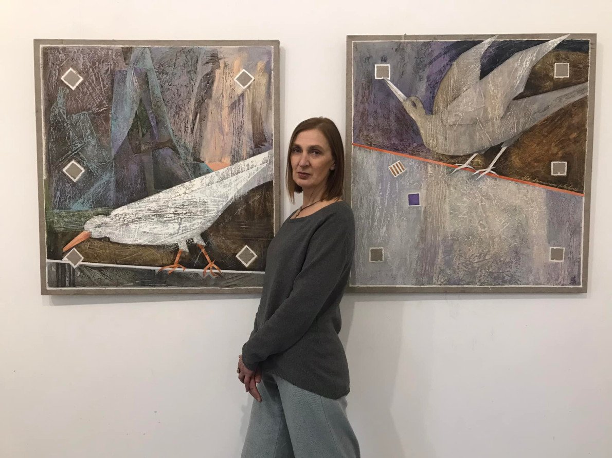 Оксана Ядчук-Мачинська на виставці біля своїх робіт. Фото: фб художниці.