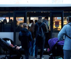 люди заходять в автобус.