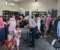 Люди різного віку беруть з полиць речі.
