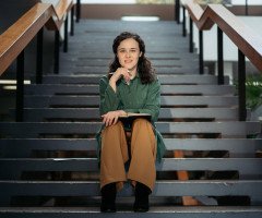 кучерява жінка сидить на сходах