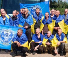 чоловіки з синьо-жовтими прапорами на плечах