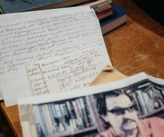 Рукописний текст та фото на письмовому столі.