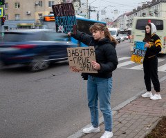 Дівчина тримає табличку з написом "Забуття гірше зради".