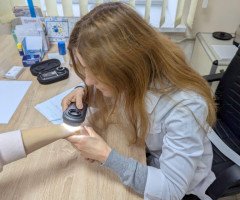 Дерматолог оглядає руку пацієнта.