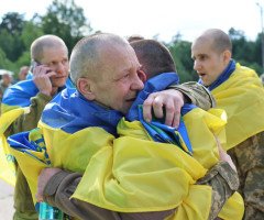 військові з жовто-блакитними прапорами на плечах
