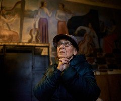 Жінка стоїть у холі колишнього парадного входу до луцького музучилища, згодом Луцької тюрми