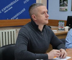 чоловік у сірому одязі сидить за столом