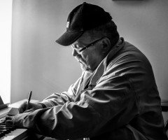 Чоловік у кепці за фортепіано.