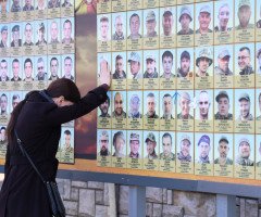 жінка біля фотостенду