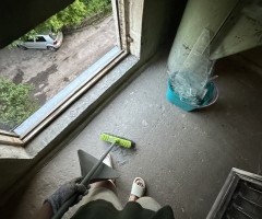 Людина підмітає розбите скло.