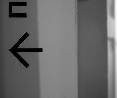 Графічне зображення на стіні у вигляді чорної стрілки ліворуч.