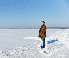 Чоловік стоїть на засніженому полі