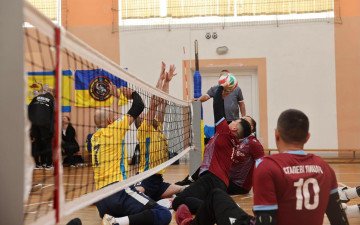 спортсмени грають у волейбол сидячи