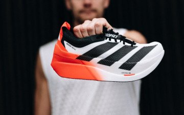 людина тримає кросівок в руках