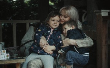 жінка обіймає двох дітей