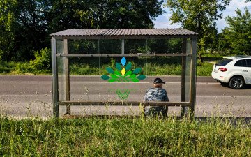 чоловік сидить на зупинці громадського транспорту