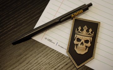 Радіодиктант національної єдності у Луцьку Листок, ручка та шеврон на столі