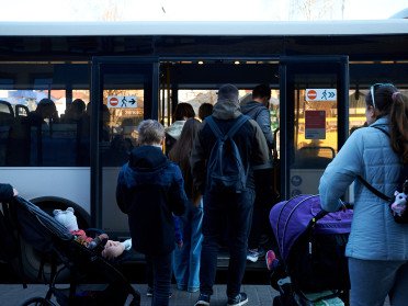 люди заходять в автобус.