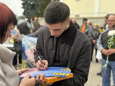 Чоловік підписує прапор