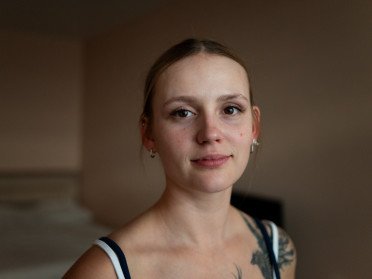 Юна дівчина з татуюванням птаха на плечі.