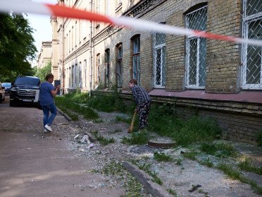 люди прибирають скло після ворожої атаки