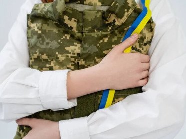 жінка пригортає до себе військову форму