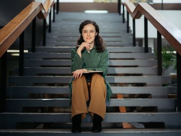 кучерява жінка сидить на сходах