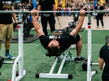спортсмен піднімає штангу