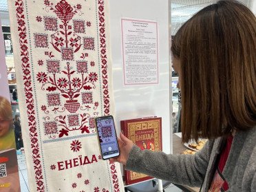 жінка сканує QR-код.