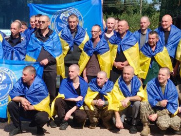 чоловіки з синьо-жовтими прапорами на плечах