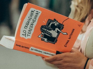 людина тримає книгу в руках