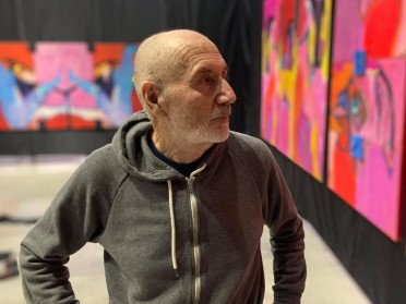 художник на фоні картин