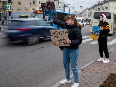 Дівчина тримає табличку з написом "Забуття гірше зради".