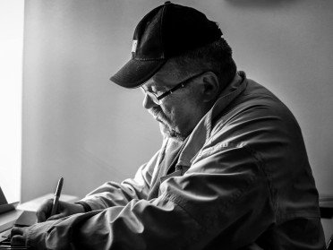 Чоловік у кепці за фортепіано.