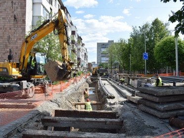 Ремонт тепломереж, багатоповерхівки, зелені дерева, комунальники у салатових жилетках, спецтехніка