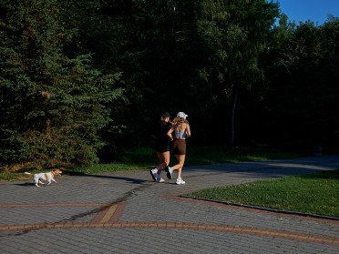 дві дівчини біжать у парку