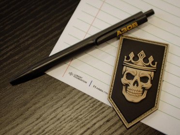 Радіодиктант національної єдності у Луцьку Листок, ручка та шеврон на столі