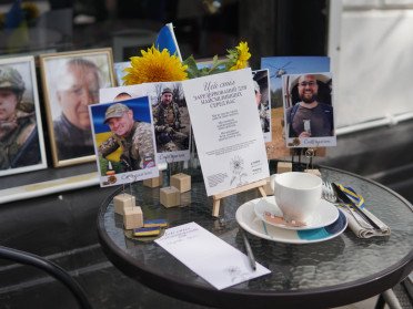 сервірований столик у кафе з портретами загиблих воїнів