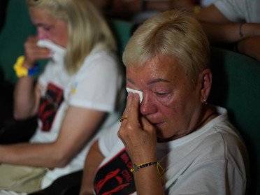 дві жінки, які плачуть та витирають обличчя від сліз