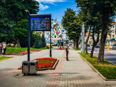 Дитина на самокаті на проспекті Волі у Луцьку біля будинку зі стінописом