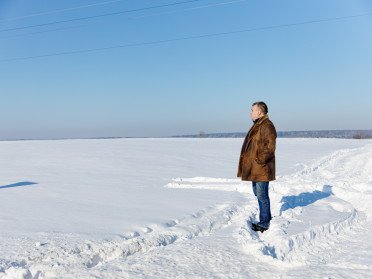 Чоловік стоїть на засніженому полі
