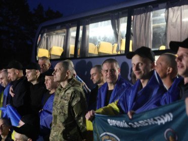 люди з прапорами на плечах