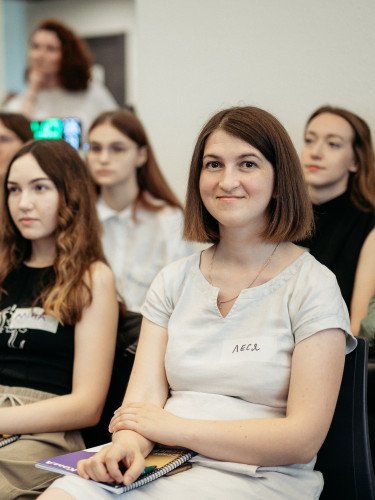жінки сидять у залі та щось уважно слухають
