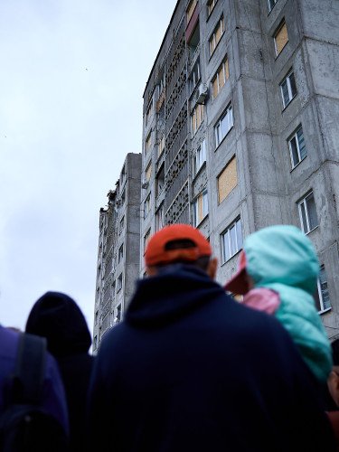Люди біля постраждалого під час російської атаки будинку в Луцьку.