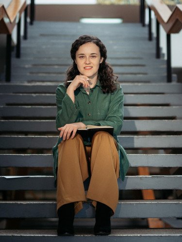 кучерява жінка сидить на сходах