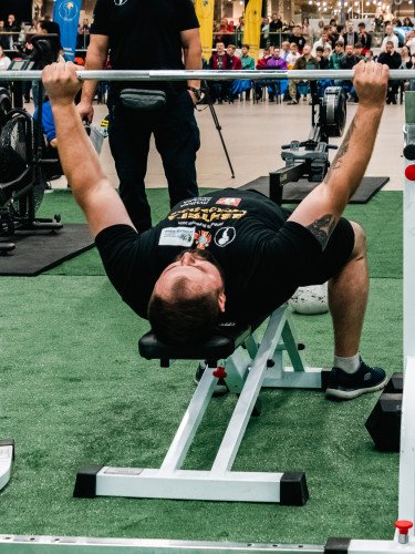 спортсмен піднімає штангу